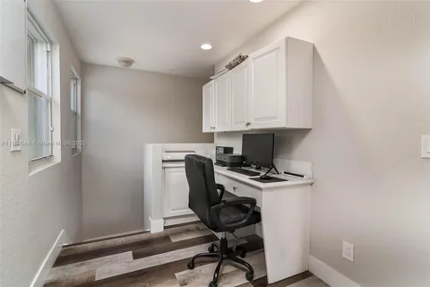 a view of workspace with wooden floor windows and cabinet