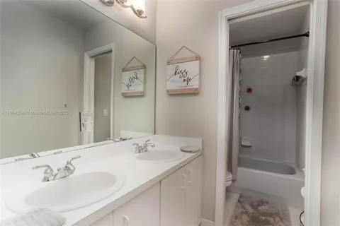 a bathroom with a bathtub shower sink and mirror