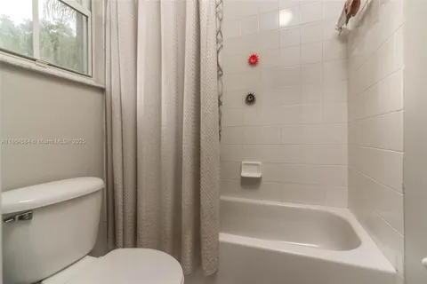 a white toilet sitting next to a bath tub