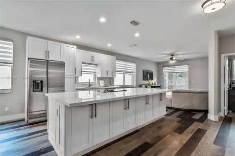 a large kitchen with kitchen island a sink stainless steel appliances and cabinets