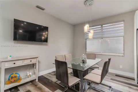 a dining room with furniture and a flat screen tv