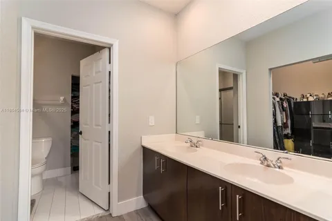 a bathroom with a double vanity sink toilet and shower