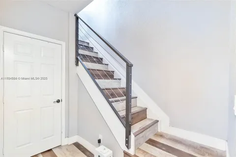 a view of staircase with railing and white walls