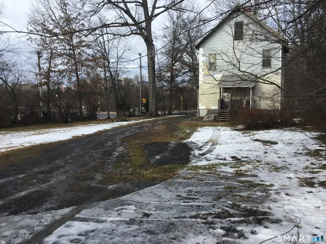 a front view of a house with a yard covered with snow