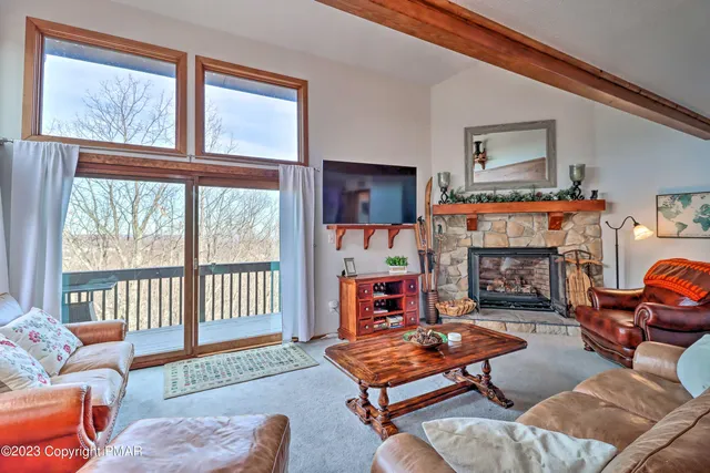 a living room with furniture a fireplace and a window