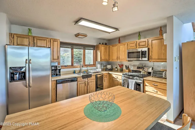 a kitchen with granite countertop a stove a sink dishwasher a refrigerator and a refrigerator