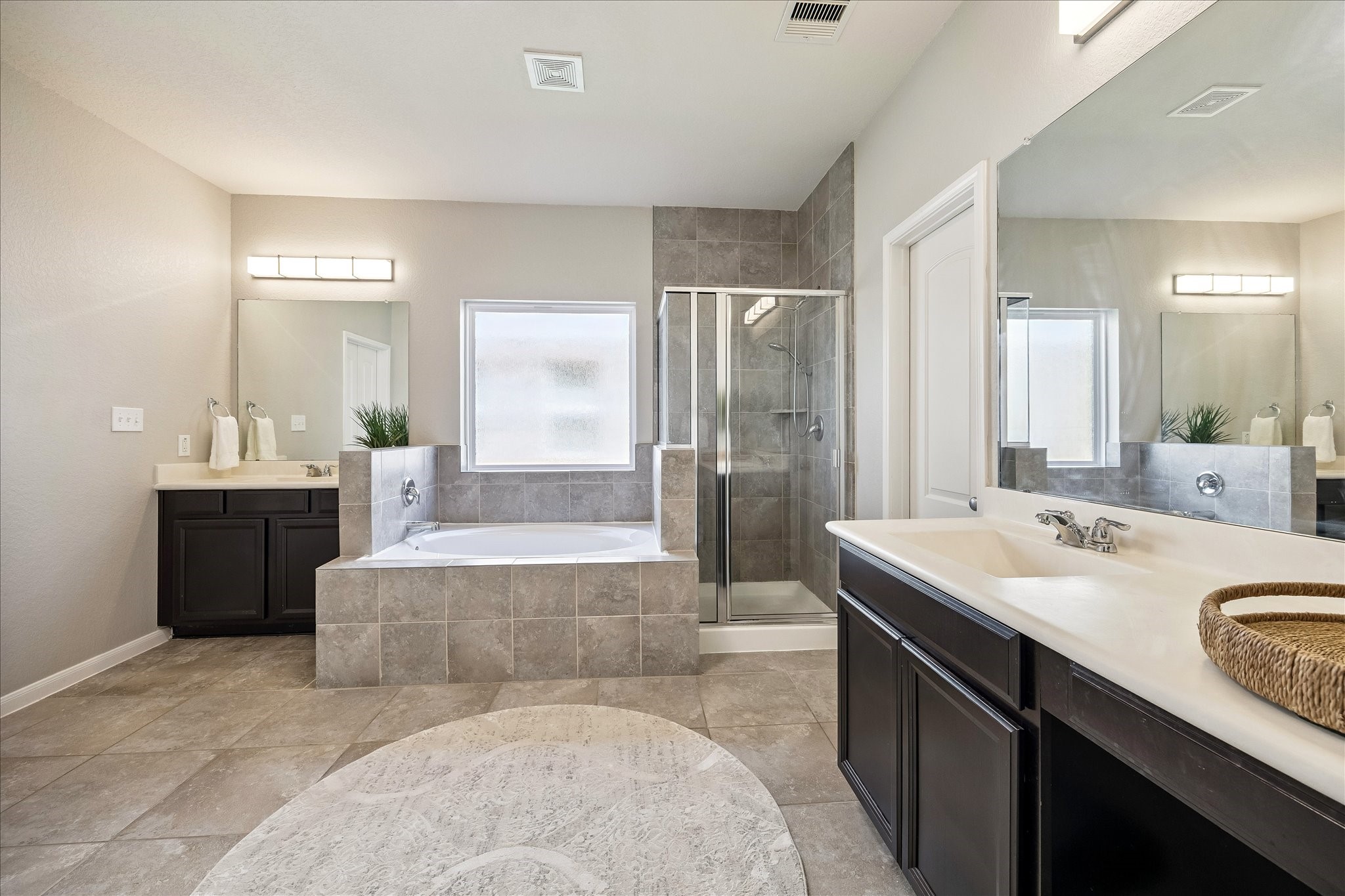 5922 Watford Bend Rosenberg, TX 77471 - Photo 11 of 34 ALTERNATE VIEW OF PRIMARY BATHROOM Tasteful tile in a timeless taupe finish spans the floor and stretches to the cewiling in the oversized shower. Deep soaking tub beckons for unwinding.