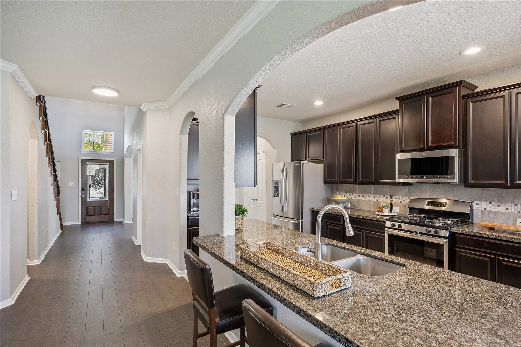5922 Watford Bend Rosenberg, TX 77471 - Photo 21 of 34 a kitchen with kitchen island granite countertop a stove refrigerator and microwave