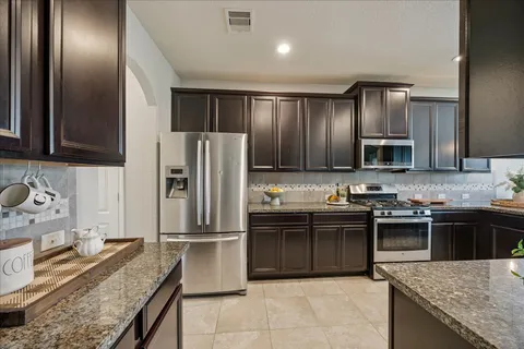 a kitchen with stainless steel appliances granite countertop a sink stove and refrigerator