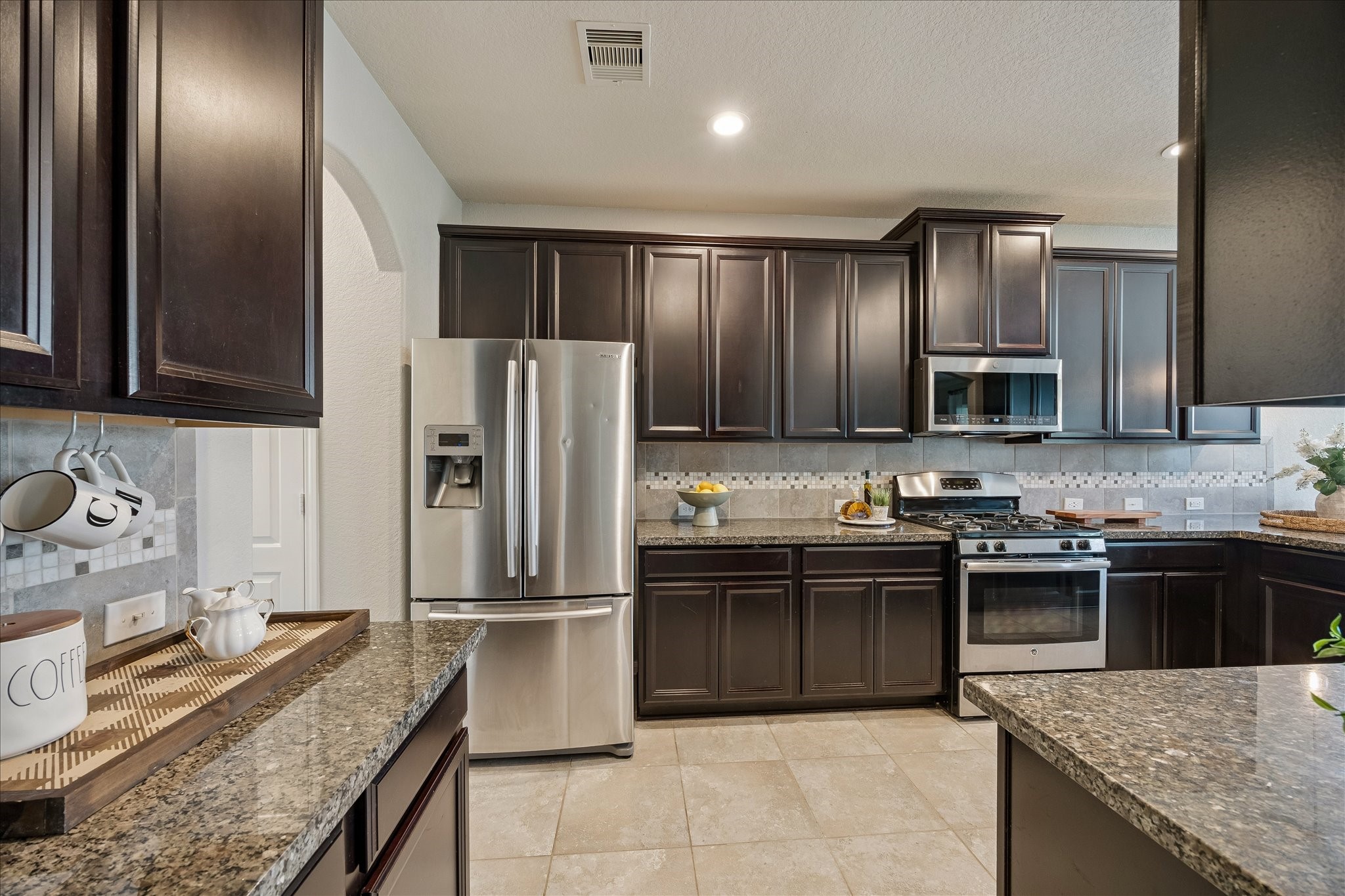 5922 Watford Bend Rosenberg, TX 77471 - Photo 3 of 34 a kitchen with stainless steel appliances granite countertop a sink stove and refrigerator