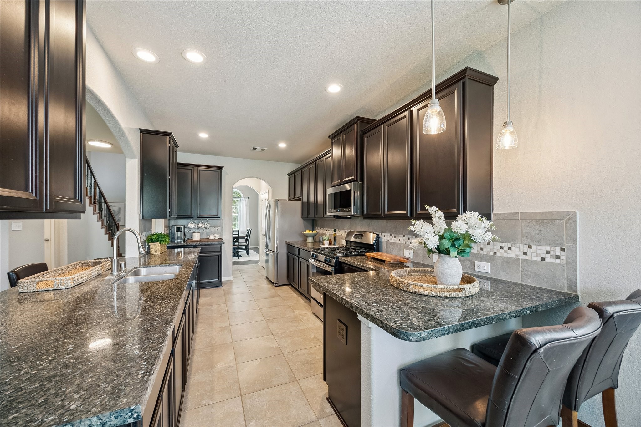 5922 Watford Bend Rosenberg, TX 77471 - Photo 3 of 34 ALTERNATE VIEW OF KITCHEN From this angle, one of two bar seating areas is shown at right. This one features pendant lighting. No one will be left out of the fun with multiple gathering spaces.