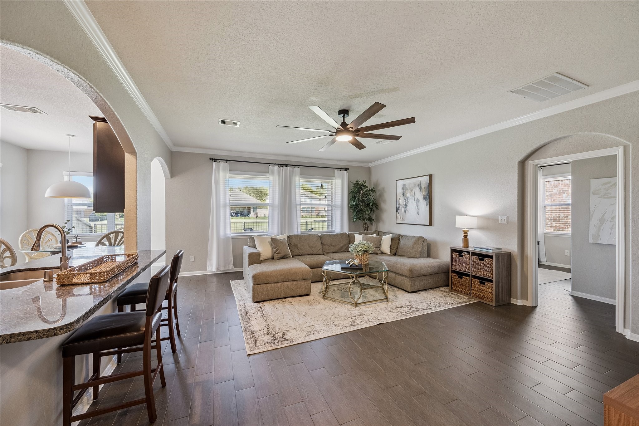 5922 Watford Bend Rosenberg, TX 77471 - Photo 4 of 34 FAMILY ROOM On trend wide plank wood look tile is durable and spans the first floor. Upgraded ceiling fan. Primary bedroom is beyond the enclave at right. Fresh neutral paint throughout.