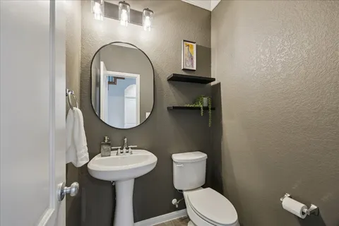 a bathroom with a toilet sink and mirror