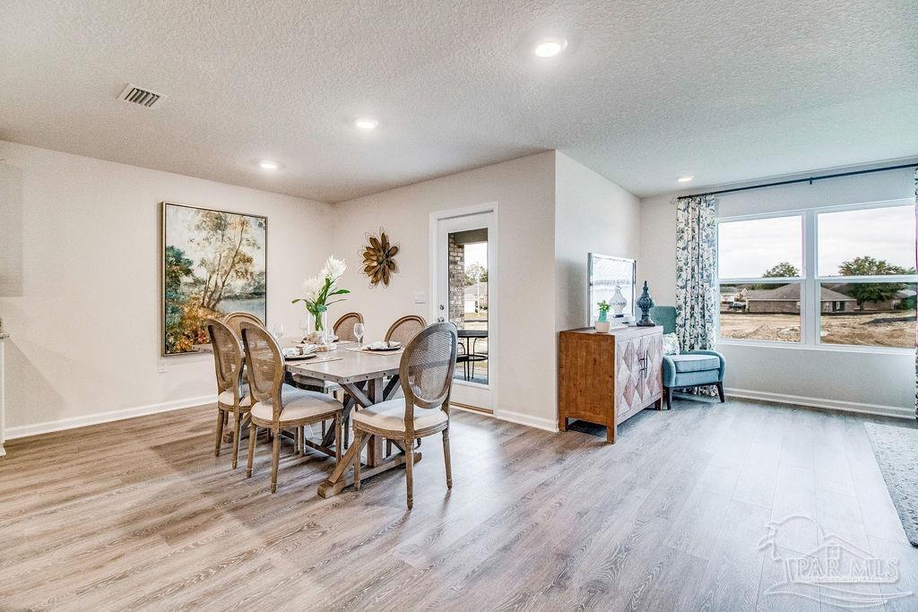 4378 Redbay Court Pace, FL 32571 - Photo 9 of 25 a view of a dining room with furniture and wooden floor