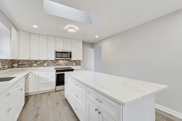 a kitchen with granite countertop white cabinets and white appliances