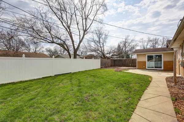 a backyard of a house with table and chairs