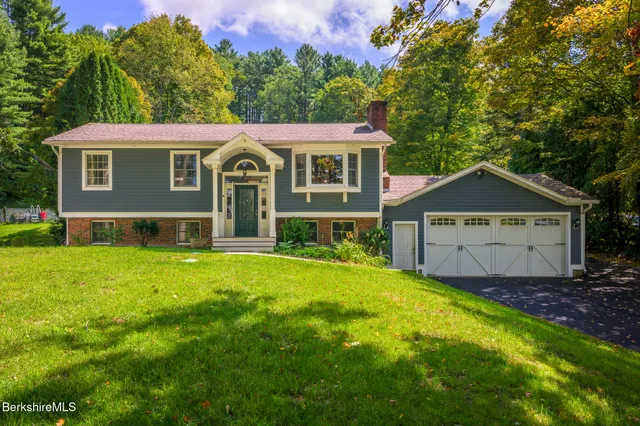 a front view of a house with yard and green space