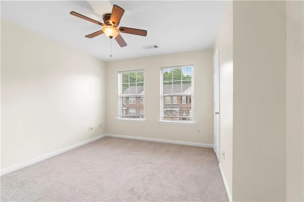 an empty room with a window and a fan