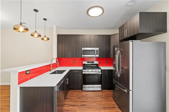 a kitchen with stainless steel appliances granite countertop a refrigerator a stove and a sink