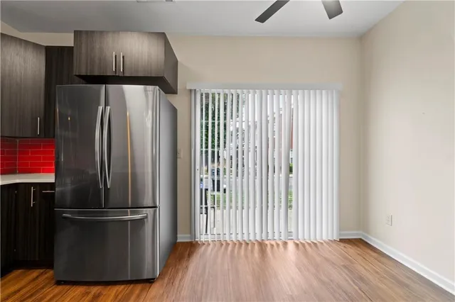 a kitchen with a refrigerator and wooden floor