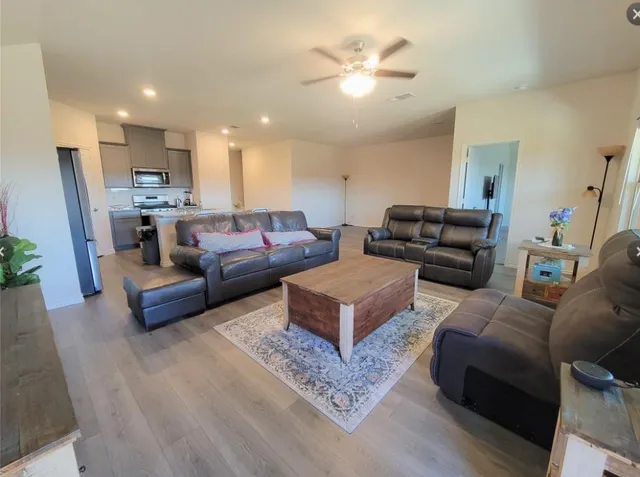 a living room with furniture and a view of kitchen