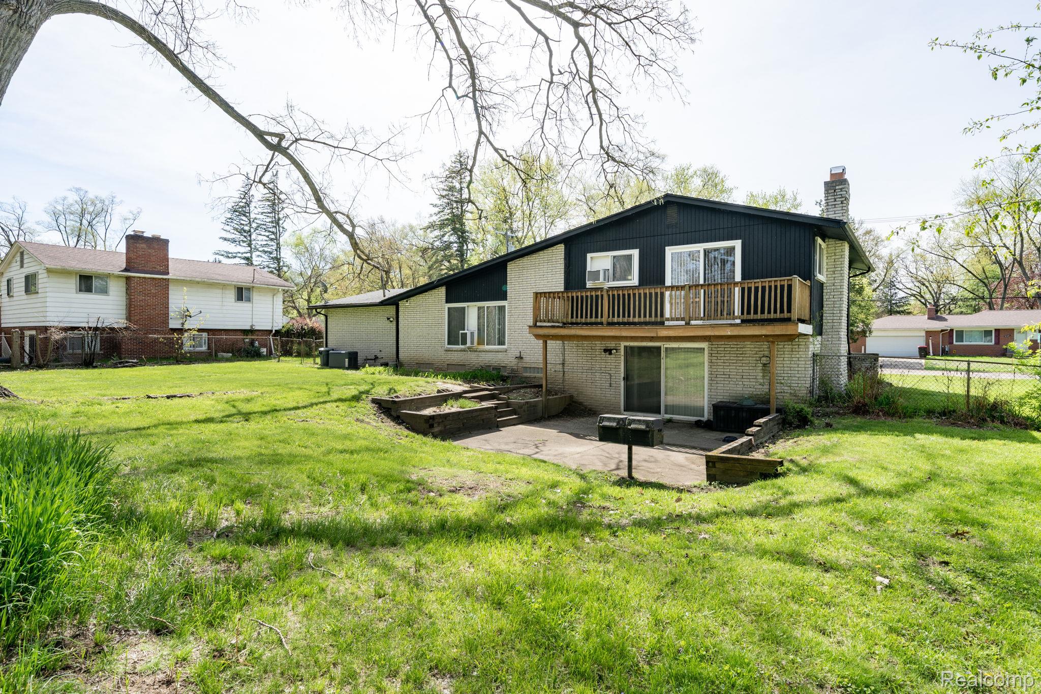 19650 Midway Road Southfield, MI 48075 - Photo 27 of 30 Rear view of property featuring brick siding, a fenced backyard, and a patio