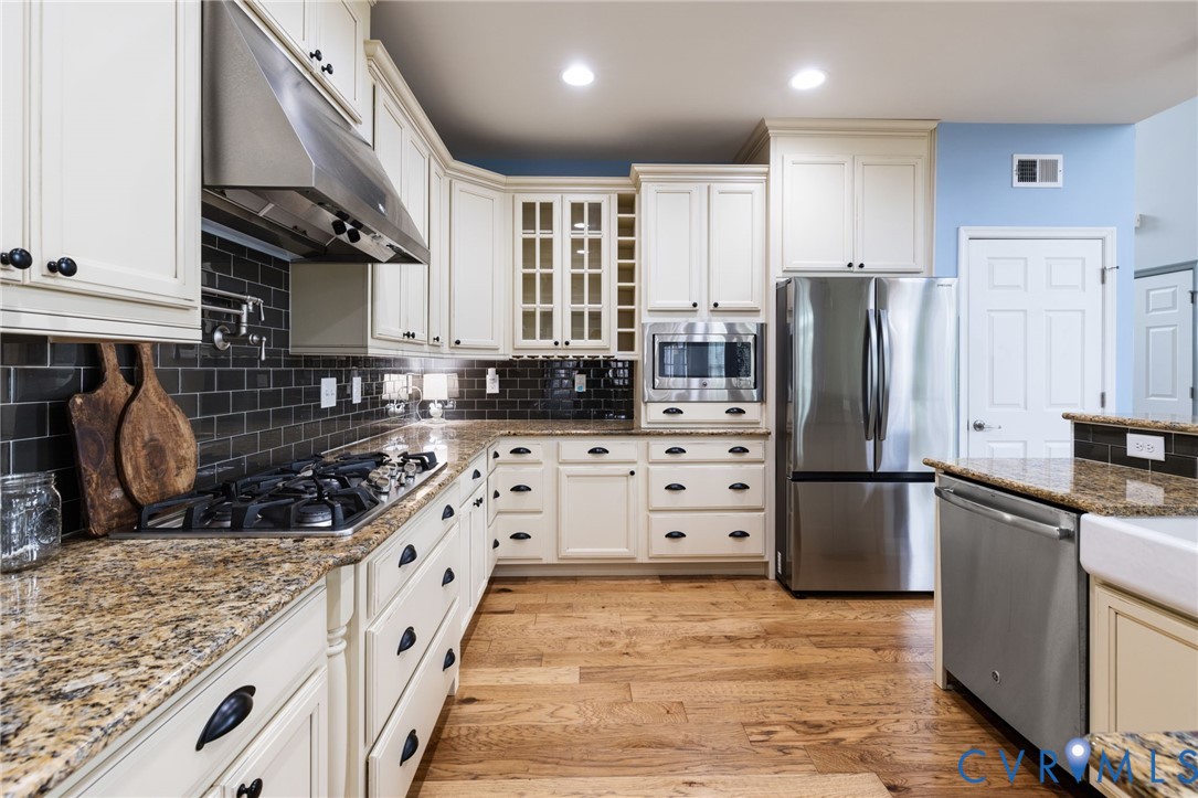16112 Garston Lane Midlothian, VA 23112 - Photo 16 of 37 a kitchen with stainless steel appliances granite countertop a refrigerator a stove and a wooden cabinets