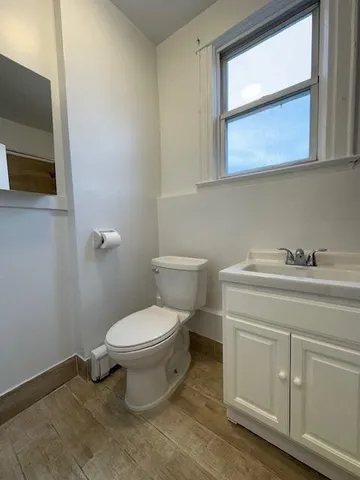a bathroom with a toilet sink and mirror