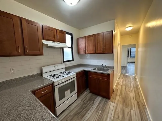 a kitchen with wooden cabinets and a stove top oven
