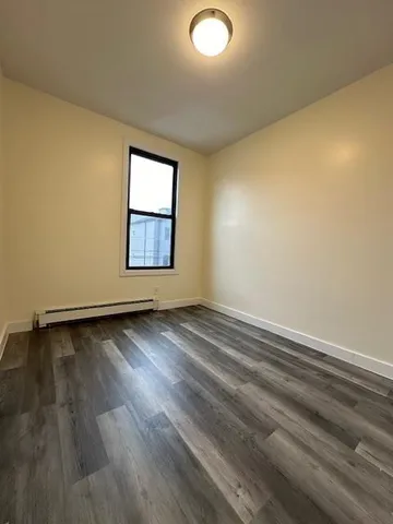a view of a room with wooden floor and window