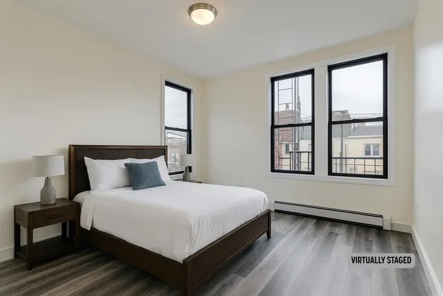a large bed sitting in a bedroom next to a window