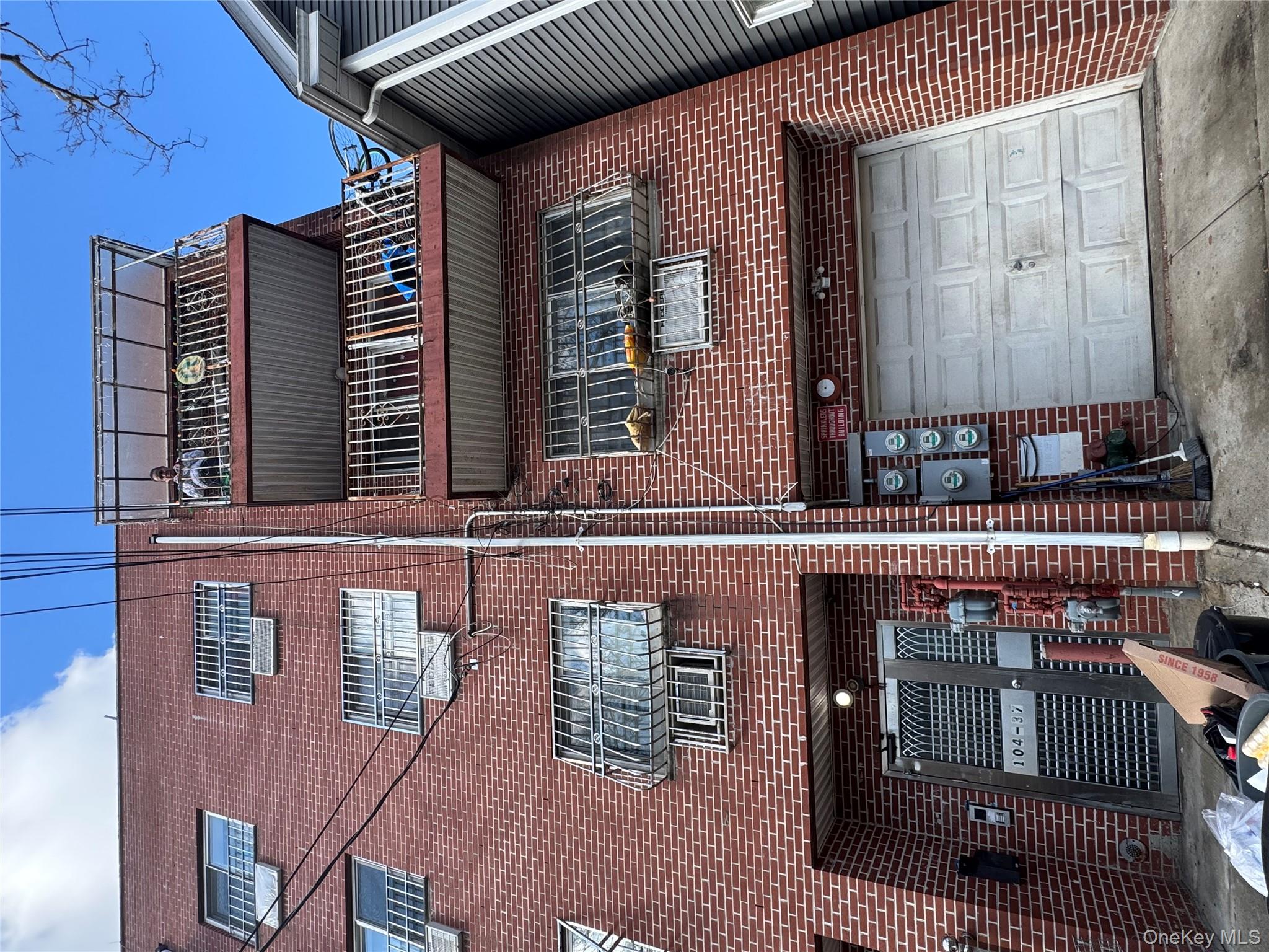 104-37 37th Road Queens, NY 11368 - Photo 2 of 10 a front view of a building with parking space