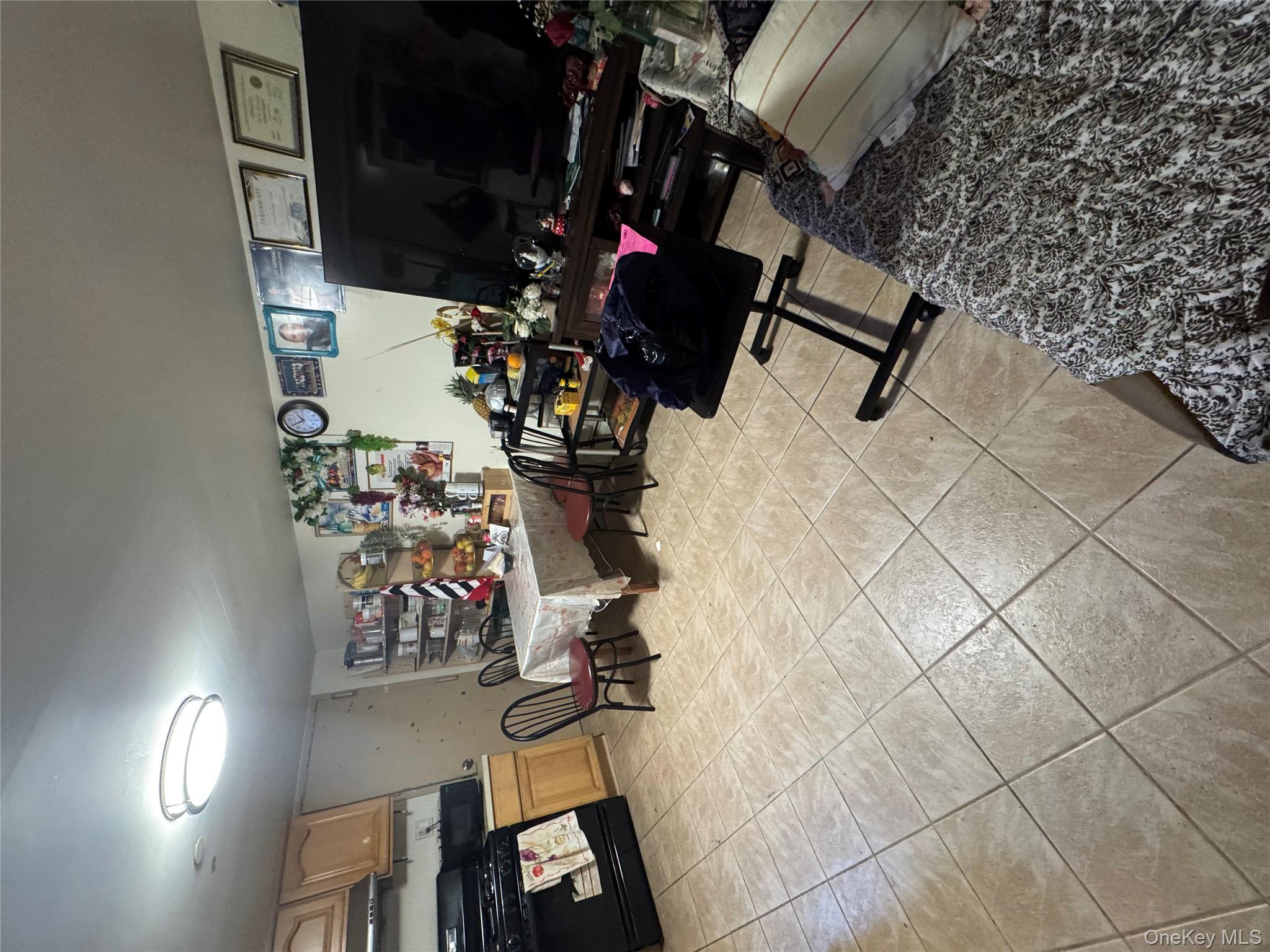 104-37 37th Road Queens, NY 11368 - Photo 4 of 10 a living room with furniture and a flat screen tv