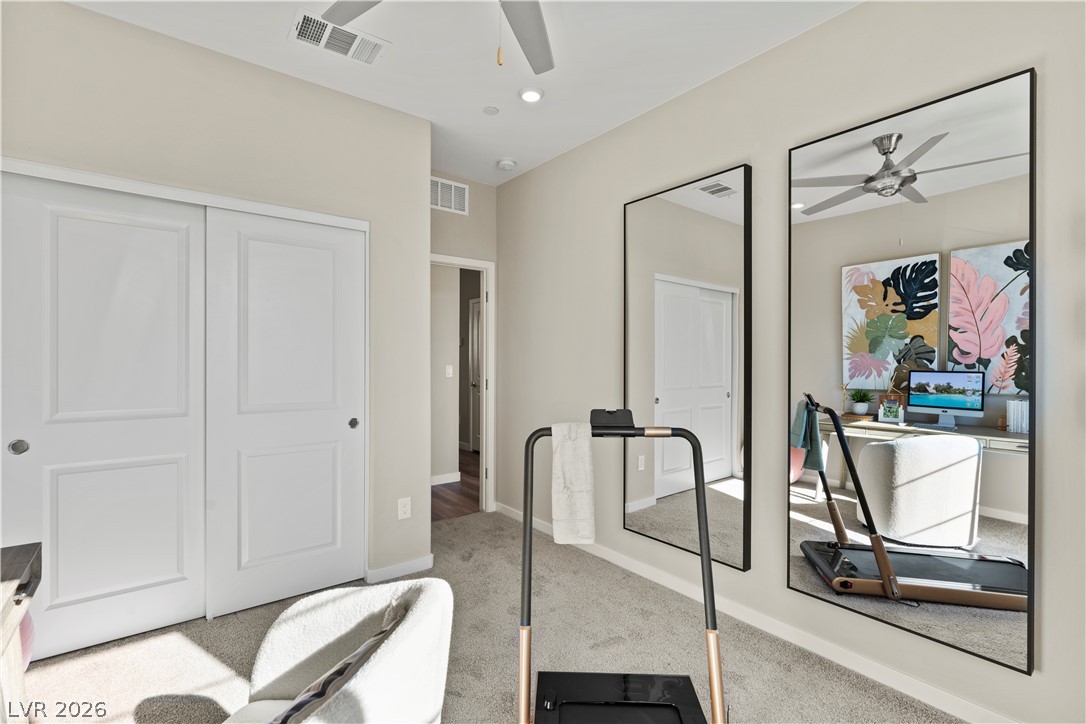 313 Keyboard Place Henderson, NV 89015 - Photo 17 of 22 A well-lit room offers versatility for exercise or a home office setup, complemented by large wall mirrors.