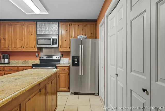 a kitchen with stainless steel appliances granite countertop a refrigerator stove and sink