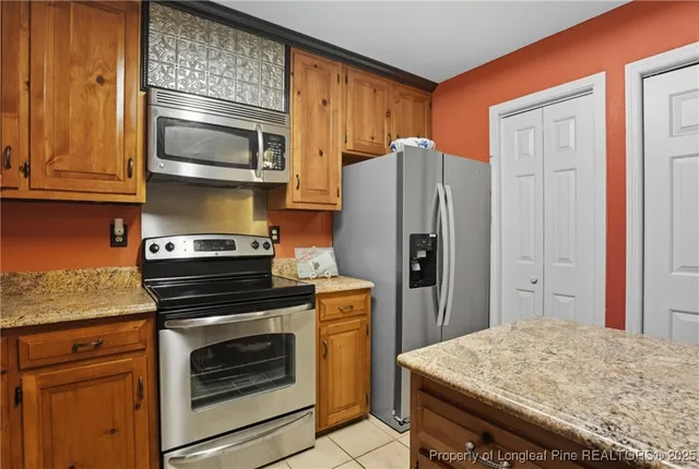 a kitchen with stainless steel appliances granite countertop a refrigerator stove and microwave