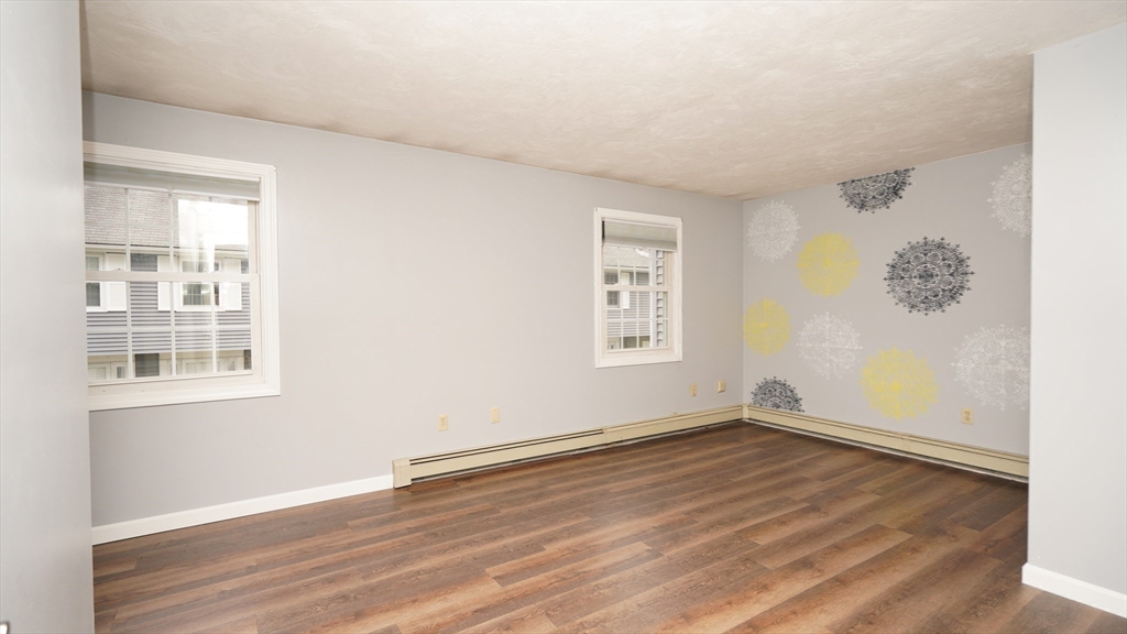 64 Mechanic Street, Unit 3 Attleboro, MA 02703 - Photo 21 of 39 a view of empty room with wooden floor and fan