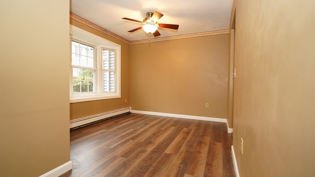 64 Mechanic Street, Unit 3 Attleboro, MA 02703 - Photo 25 of 39 an empty room with wooden floor ceiling fan and windows
