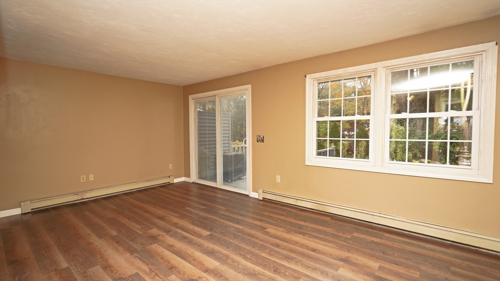 64 Mechanic Street, Unit 3 Attleboro, MA 02703 - Photo 26 of 39 a view of an empty room with a window and wooden floor