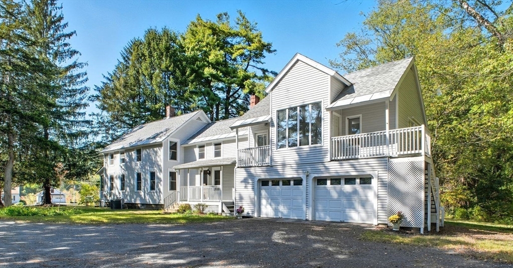 259 Long Plain Road Leverett, MA 01054 - Photo 2 of 39 a view of a white house with large windows and a small yard