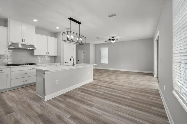 a view of a kitchen with center island and wooden floor