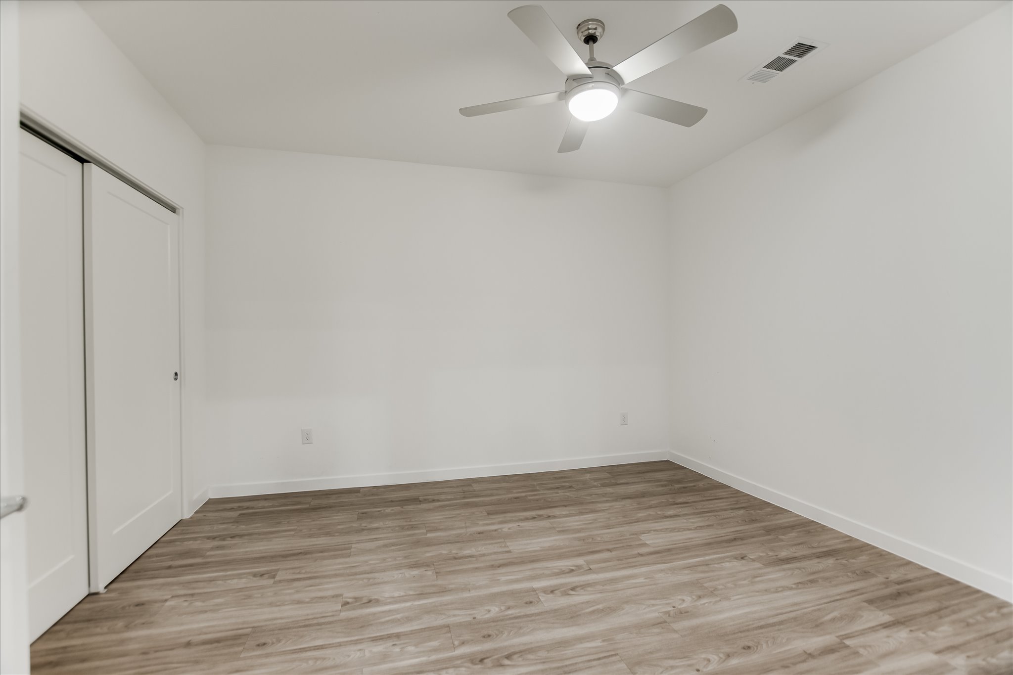 4801 Springdale Road, Unit 1207 Austin, TX 78723 - Photo 7 of 10 Unfurnished bedroom with a closet, light wood-type flooring, and a ceiling fan