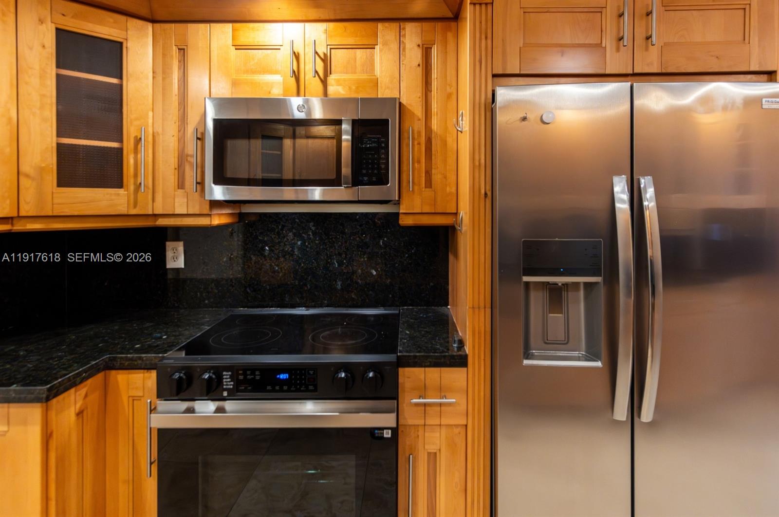 145 Southeast 25th Road, Unit 1003 Miami, FL 33129 - Photo 17 of 43 a kitchen with stainless steel appliances granite countertop a stove and a microwave