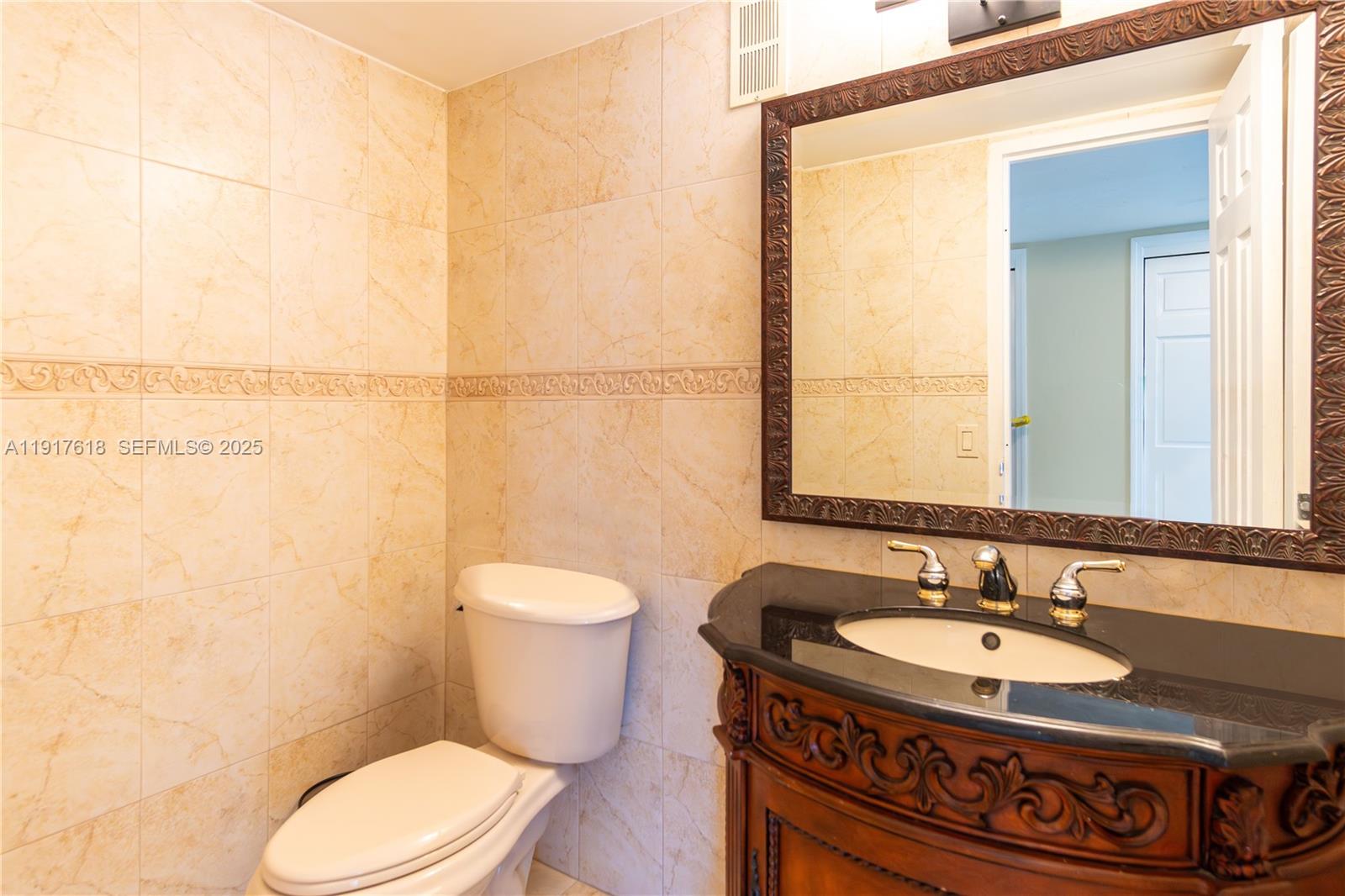 145 Southeast 25th Road, Unit 1003 Miami, FL 33129 - Photo 33 of 43 a bathroom with a sink a toilet and a mirror