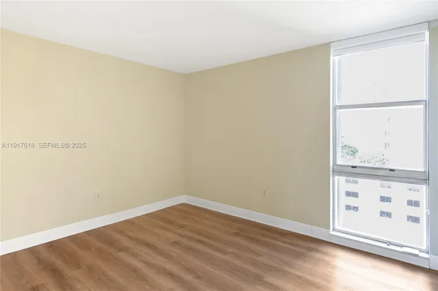 an empty room with wooden floor and closet
