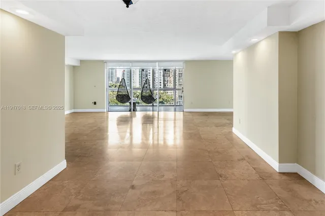 a living room with furniture floor to ceiling window and wooden floor