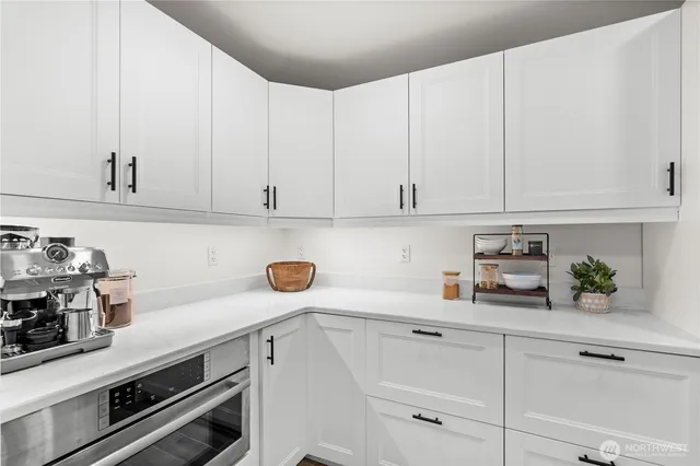 a kitchen with white cabinets and white appliances