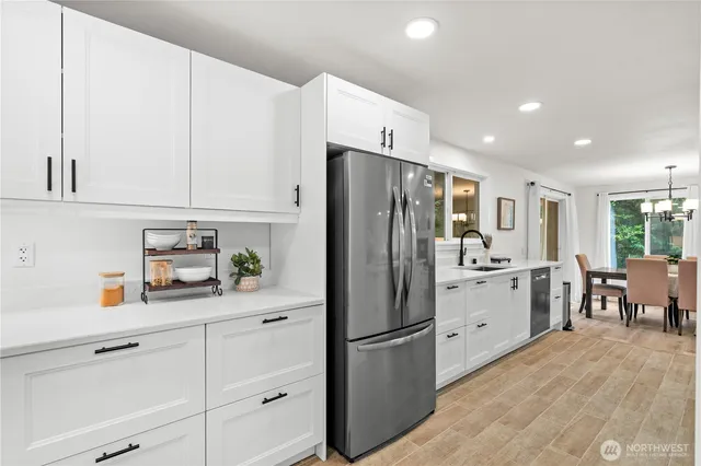 a kitchen with appliances a refrigerator and cabinets