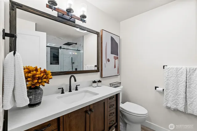 a bathroom with a sink a toilet and mirror