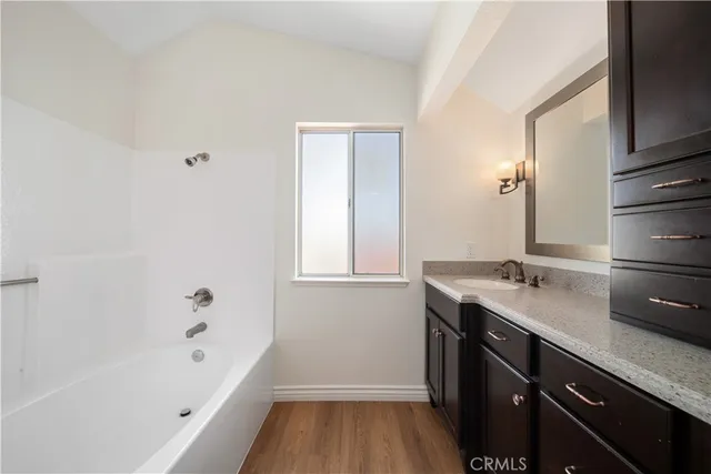 a bathroom with a tub sink and mirror